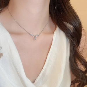 Détail macro du collier pendentif en V serti de zircons sur une fine chaîne en argent