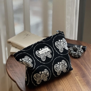 Gros plan sur la broderie papillon et l'étiquette en tissu sur le sac en toile noir