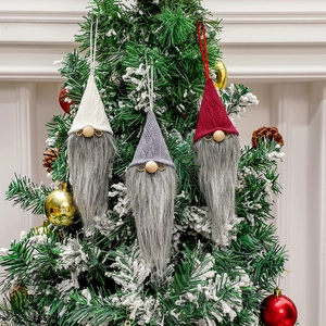 Three-piece Christmas gnome ornaments with knitted hats on a decorated tree branch