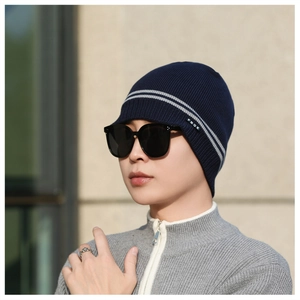 Detail of navy knit beanie with gray stripes and soft ribbed texture for winter warmth