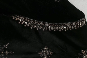 Détail macro du velours de soie noir avec broderie de fils de bronze et sequins brillants