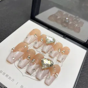 Faux ongles rose nude marbré avec diamants en cœur et cristaux élégants