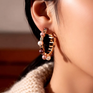 Detailed view of French vintage gold hoop earrings with multi-color pearls on a model