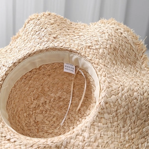 Detail of raffia sun hat with adjustable inner drawstring and premium paper weave texture