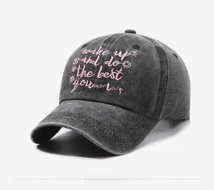 Detailed side view of washed dark grey denim baseball cap with pink floral embroidery