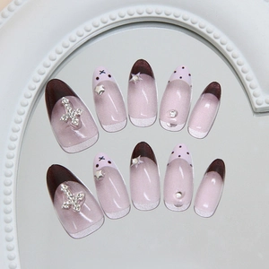 Pink and brown French cat eye press-on nails with silver cross and star accents