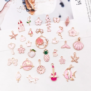 Flat lay of pink enamel alloy charms featuring flamingo, shell, and floral motifs