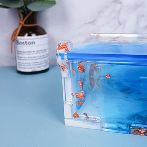 Detailed macro view of a blue resin storage box with gold leaf flakes and white base