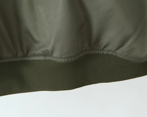 Detailed macro view of military green jacket with ribbed hem and high-density twill fabric