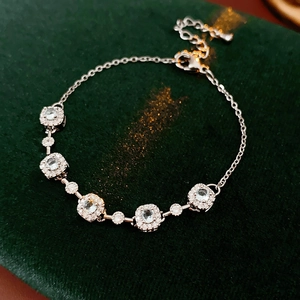 Détail macro du bracelet en zircone sur velours vert montrant le fermoir mousqueton