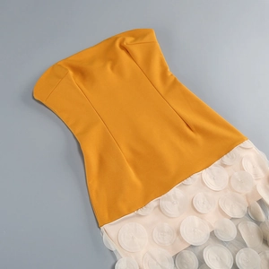 Detail of ginger yellow tube top dress with apricot pink textured mesh and floral stitching