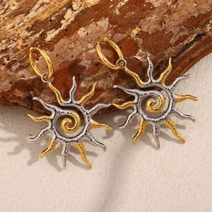 Vue macro détaillée des boucles d'oreilles soleil bicolores en acier plaqué or 18 carats