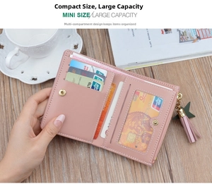 Detail of pink bifold wallet interior showing five card slots and star tassel on wood table