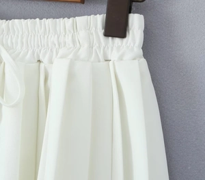 Detailed view of elastic waist and precise pleats on this white mini skirt for women