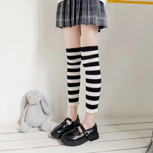 Detailed close-up of black and white striped knit leg warmers with ribbed texture detail