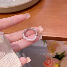 Detailed shot of handmade elastic ring with silver beads and faux white pearls