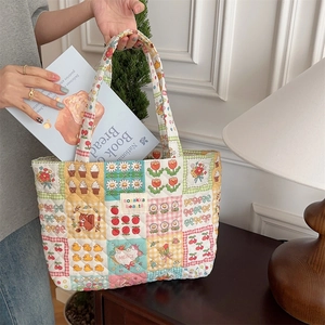 Detail of quilted tote bag with floral patches being used as a book bag in a cozy room
