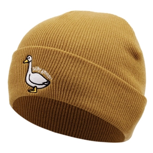 Detail of silly goose embroidery on a mustard yellow cuffed knit beanie hat