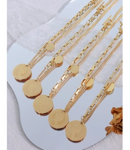 Macro detail of French style gold-plated portrait coin pendant on a double layer chain