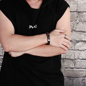 Detail of men's black braided leather bracelet with punk gear metal buckle on wrist