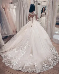Detail of back lace-up closure and long lace sleeves on an ivory cathedral train gown