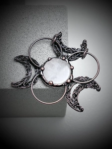 Detailed view of handmade biohazard symbol pendant with raw white quartz stone