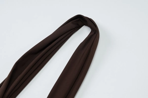 Detail showing smooth dark brown knit fabric texture and elegant flowing drape style