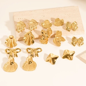 Detailed view of various vintage 18K gold-plated geometric earrings on a stone base
