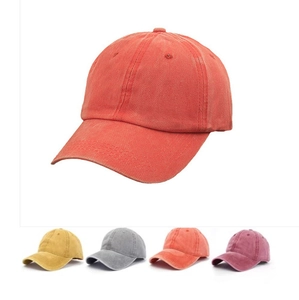 Detail of washed cotton baseball caps in vibrant orange, yellow, grey and rose pink shades