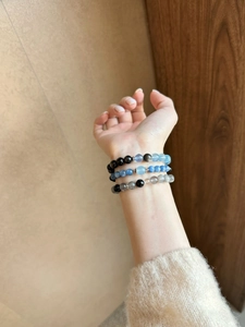 Close-up of beaded moonstone and silver obsidian multi-layer bracelet on wrist