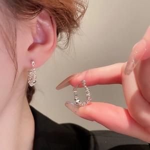 Close-up of S925 silver square earrings with diamond accents and pearls being held