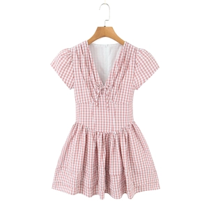 Mini-robe à carreaux rose et blanc avec décolleté en V et nœud sur un cintre