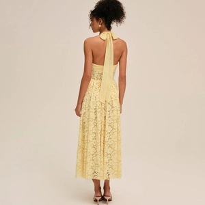 Vue arrière détaillée d'une robe jaune en dentelle avec grand nœud et dos nu élégant