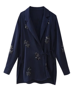 Detailansicht eines marineblauen Satin-Blazers mit schwarzen Pailletten und Bindeband