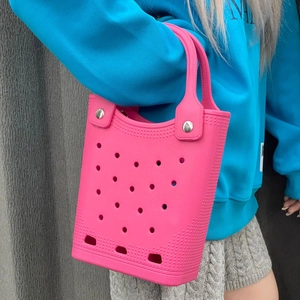 Pink EVA beach tote bag shown on model arm with stylish circular perforated holes design
