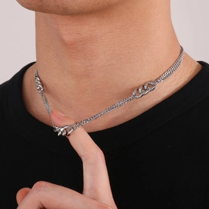 Close-up of layered silver Cuban chain necklace on model for a trendy minimalist look