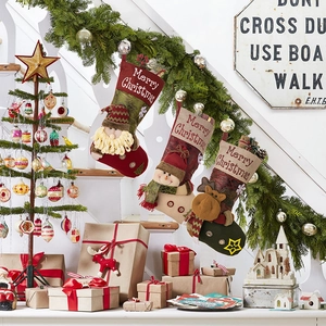 Three festive Christmas stockings with Santa, snowman and reindeer on a decorated staircase