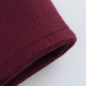 Macro shot of burgundy fleece coat sleeve showing premium stitching and fabric texture