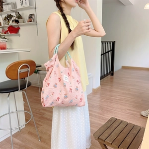 Pink tote bag detail with cute bear and bow patterns and aesthetic woven tag