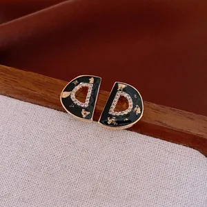 Vintage gold 'D' earrings with black enamel gold leaf and zircon pavé inlay