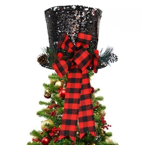 Close-up of black sequin Christmas tree topper hat with buffalo plaid bow and pine cones