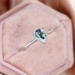 Elegant water drop moss agate ring with silver three-claw setting on pink velvet box