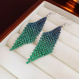 Détail macro de boucles d'oreilles losanges avec dégradé de strass bleus et verts