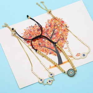 Close-up of golden Evil Eye bracelet set with blue zircon accents and beaded details