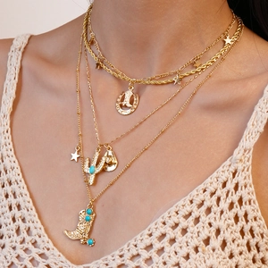 Detail of layered gold necklace with cowboy hat cactus and turquoise pendants