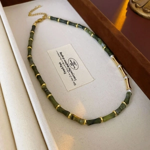 Detail of bamboo joint necklace with green jade beads, gold metal, and white pearls