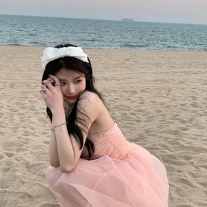 Elegant white double-layered bow headband for women shown on a model by the beach