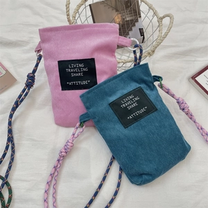 Detail of corduroy mini crossbody bags with woven rope straps and textured fabric finish