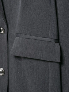 Détail de la texture sergé gris foncé avec des boutons métalliques argentés sur le blazer