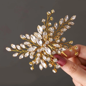 Detailed view of a golden leaf bridal hair comb set with sparkling clear crystals